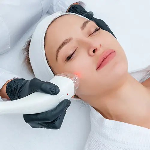 Woman with closed eyes going through laser treatment