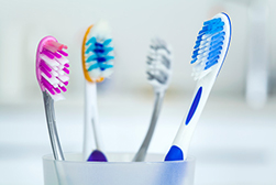 4 toothbrushes in a cup from The Facial Center in Charleston, WV