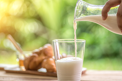 A glass of milk being poured