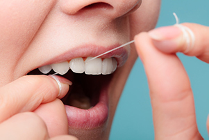 A close up of a person flossing their teeth