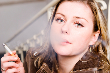 White woman blowing smoke from a cigarette