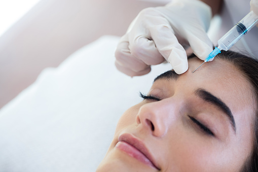 a woman receving Botox injections from a doctor