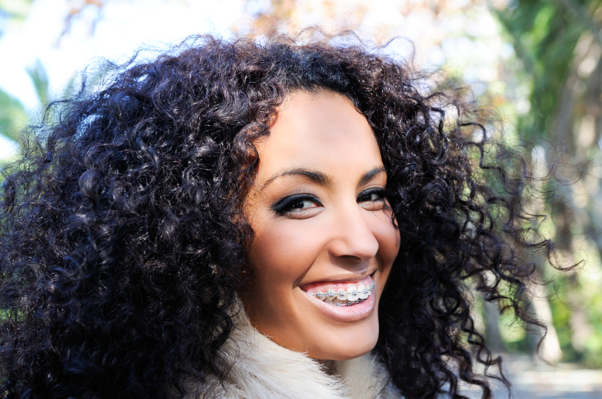 Woman with curly hair and braces smiling